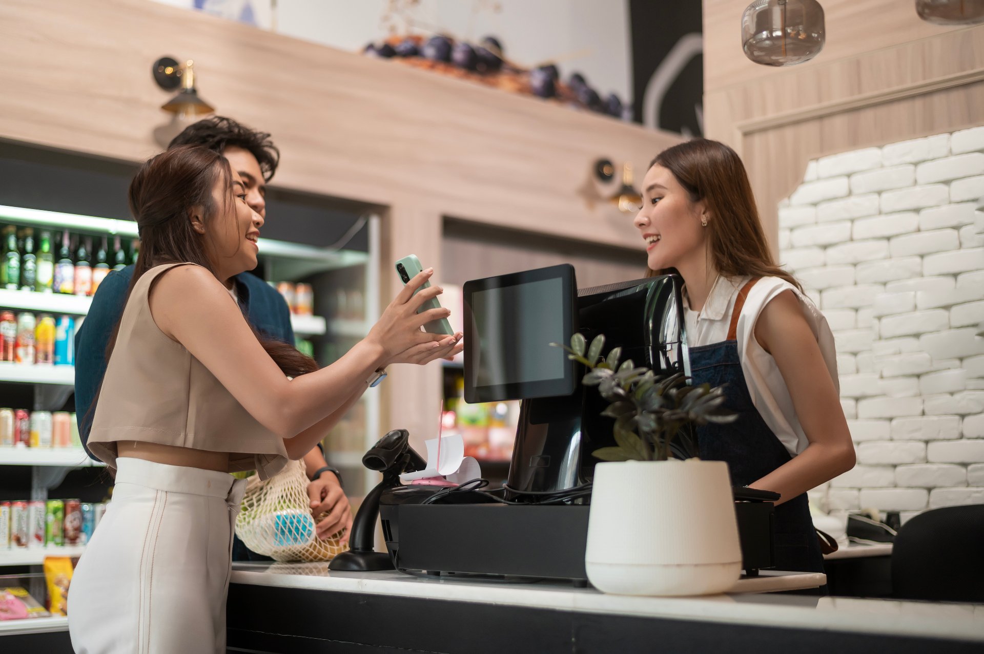 Cliente pagando com celular no caixa de uma loja